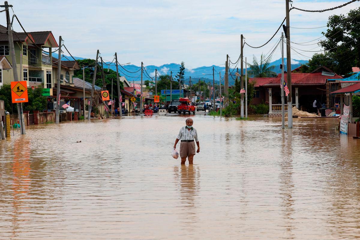 Seorang warga emas meranduk banjir yang menenggelamkan jalan utama Hulu Langat di Kampung Sungai Serai ketika tinjauan Bernama hari ini- BERNAMA
