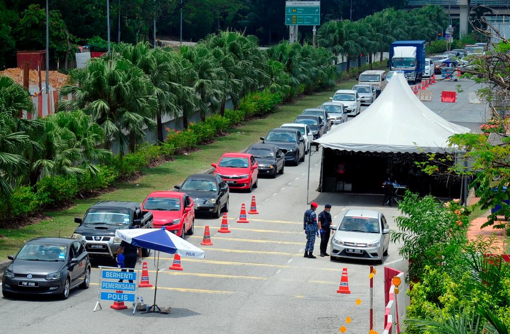 PDRM assists members of the RMAF from Subang Air Base conduct a roadblock during the implementation of the second phase of the Movement Control Order in Shah Alam today. - Bernama