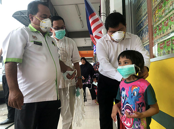 Selangor Environment, Green Technology, STI and Consumer Affairs Committee chairman Hee Loy Sian distributing face masks to residents of Taman Setia yesterday. — Bernama