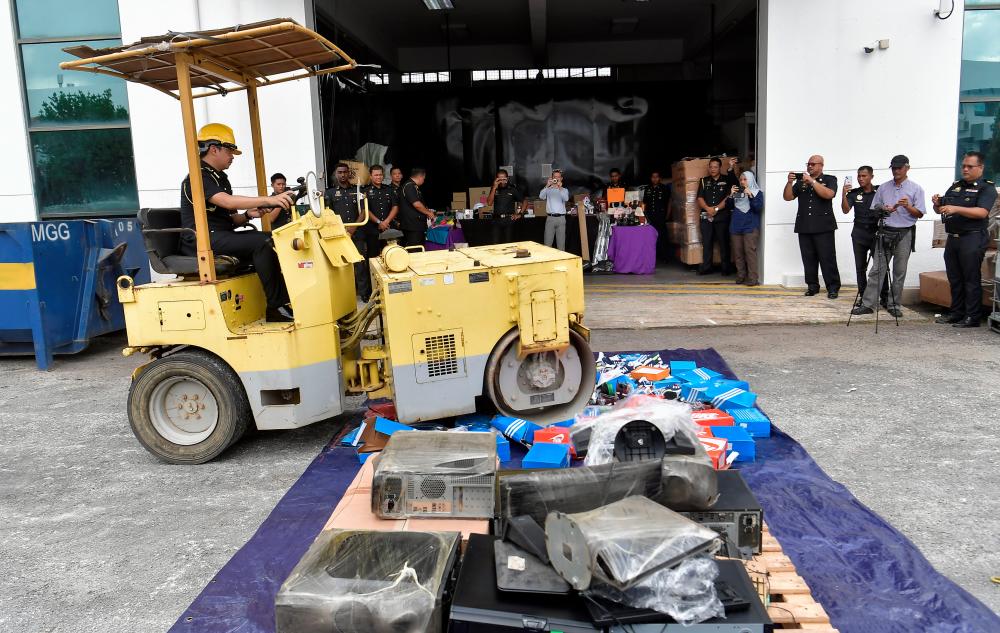 SHAH ALAM, 29 Ogos -- Pengarah Kementerian Perdangangan Dalam Negeri dan Kos Sara Hidup (KPDN) Selangor Mohd Zuhairi Mat Radey (kiri) melihat proses Pelupusan Ekshibit Perdana 2023 di Stor Penyimpanan Ekshibit KPDN Selangor di Bukit Raja Shah Alam hari ini. fotoBERNAMA