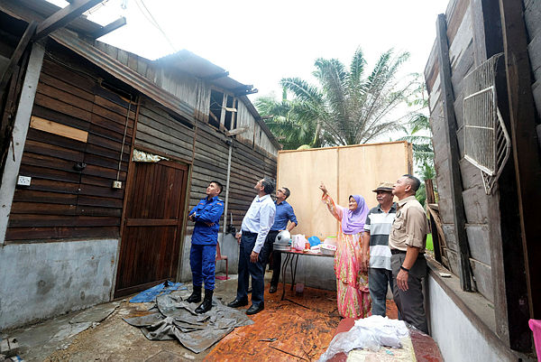 Special Officer (economy) to the Deputy Prime Minister, Ameer Ali Vali Mohamed office (2nd from L) visits the home of a storm survivor, Maznah Sanusi, 61, (3rd from R), devastated by Typhoon Lekima at Kampung Sawah Sempadan, Tanjung Karang. — Bernama