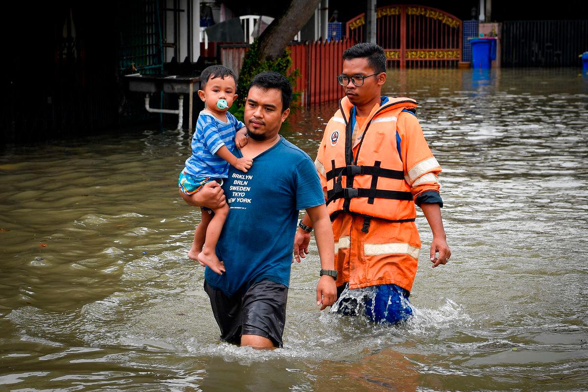 Pasukan keselamatan membantu mengeluarkan mangsa ke kawasan selamat selepas kediaman mereka dinaiki air ekoran hujan lebat berterusan selama tiga jam ketika tinjauan fotoBernama di Taman Bukit Kemuning, Seksyen 32 pagi ini -BERNAMA