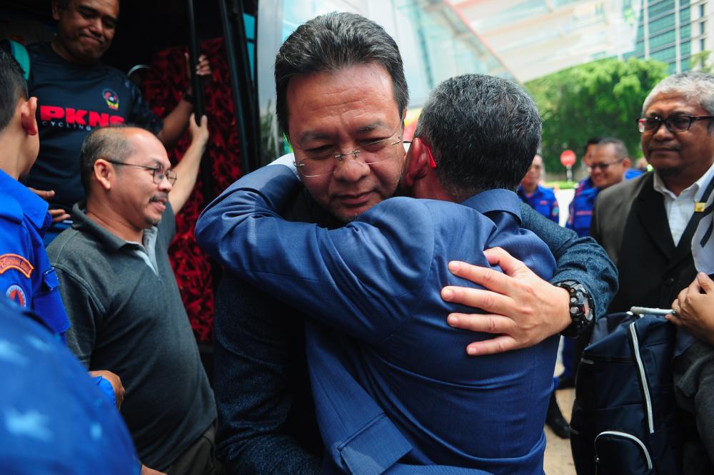 PKNS CEO Datuk Azizi Mohd Zain (R) hugs a survivor of the bus crash and PKNS staff member Bakhtiar Effendi Hamzah after arriving at the PKNS headquarters building in Section 14 today. - Bernama