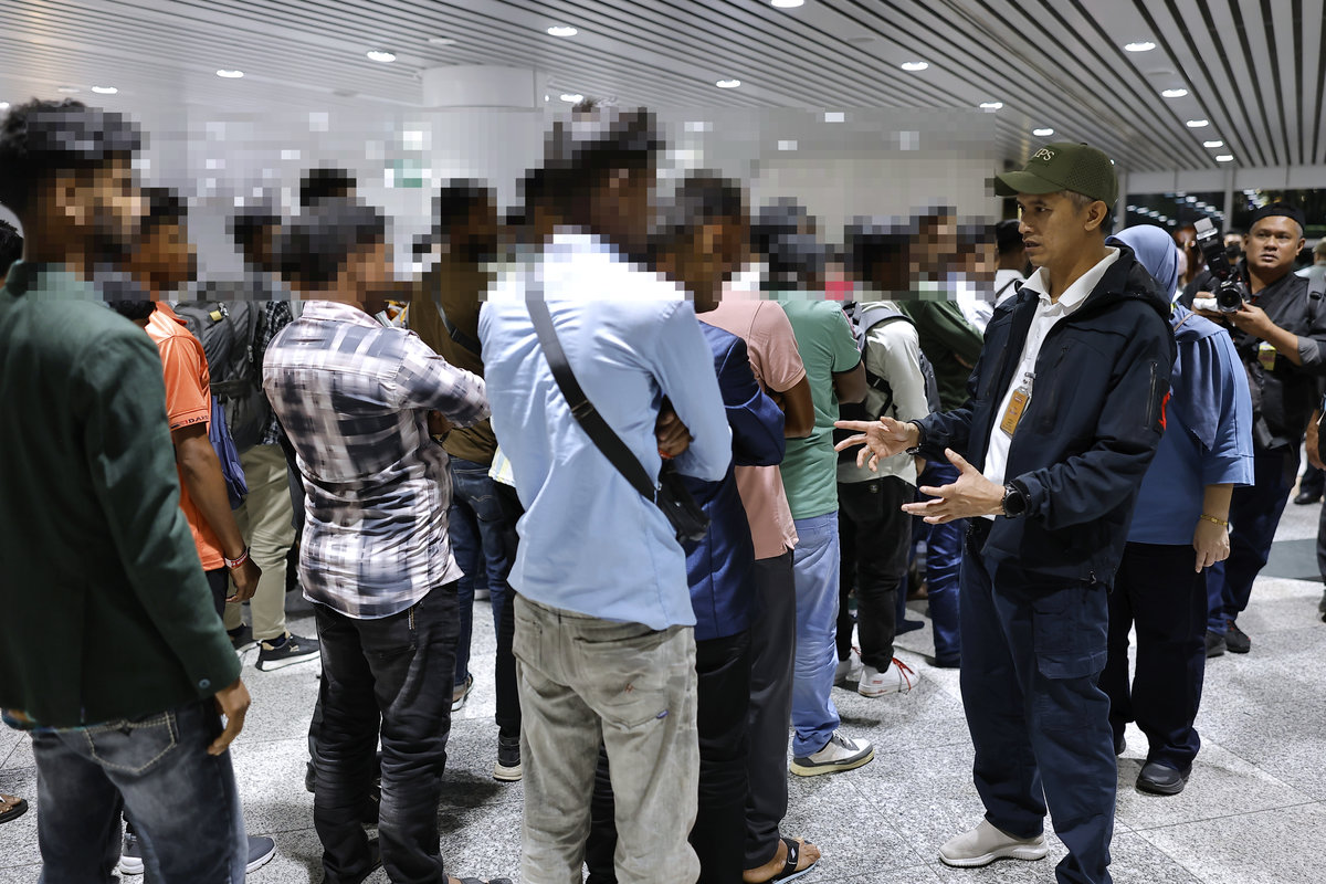 Director-General of the Malaysian Border Control and Protection Agency (AKPS), Datuk Seri Mohd Shuhaily Mohd Zain (right), with the foreign nationals who were detained at Kuala Lumpur International Airport (KLIA) yesterday. – BERNAMA
