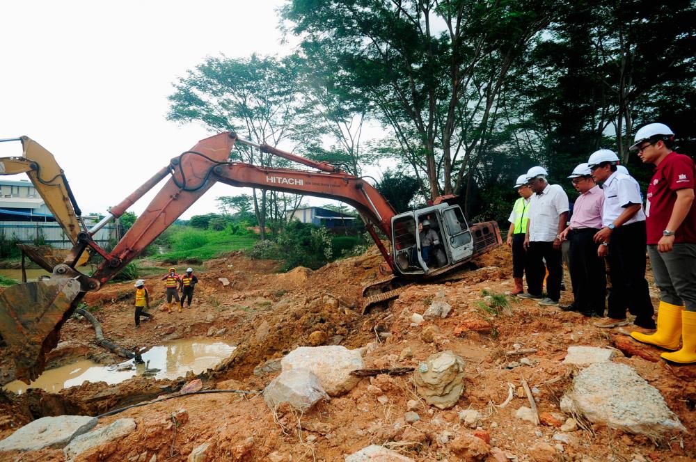 SPAN chairman and Klang MP, Charles Santiago (4th from R), reviews the repairs works of the burst pipe in Setia Alam, today. = Bernama