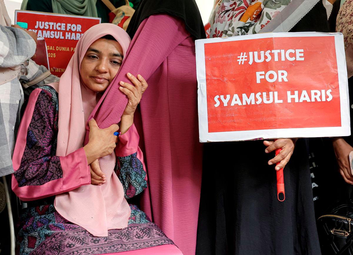 Ibu kepada pelatih Pasukan Latihan Pegawai Simpanan (Palapes) Universiti Teknologi Malaysia (UTM) Skudai, Syamsul Haris Shamsudin, Ummu Haiman Bee Daulatgun ditenangkan ahli keluarga dan sanak saudara semasa proses penggalian semula kubur anaknya di Tanah Perkuburan Islam Kampung Rinching Ulu. - BERNAMA