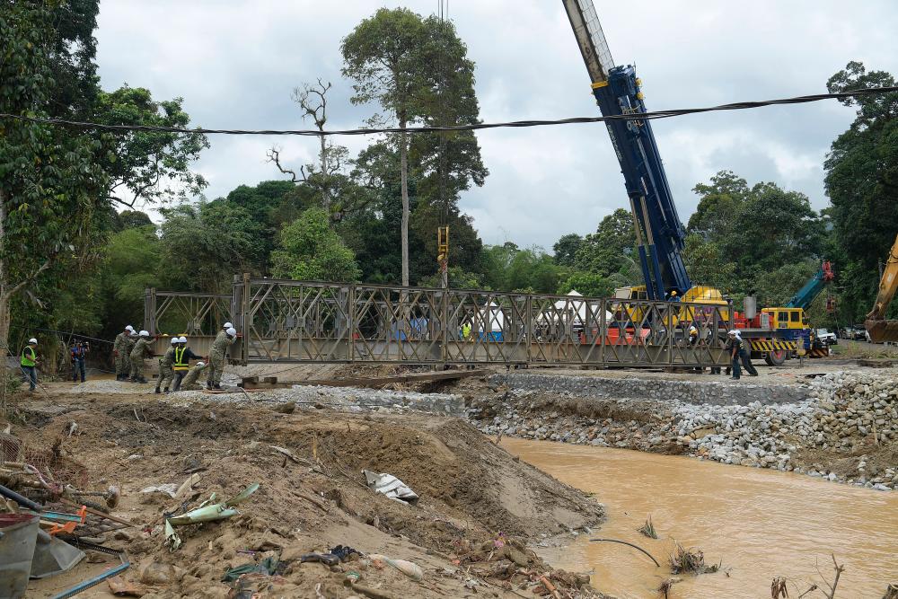 HULU LANGAT, 2 Jan -- Jurutera Jabatan Kerja Raya (JKR) bersama Anggota Tentera Malaysia dari Rejimen Askar Jurutera DiRaja Tentera Darat membuat kerja-kerja melaeakkan jambatan sementara di Sungai Lui hari ini.--fotoBERNAMA