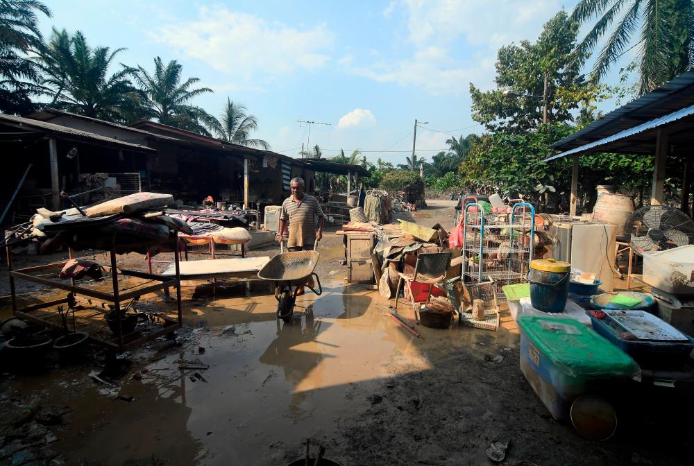 BANTING, 26 Dec -- A villager, Roslin Pahing, 52, doing cleaning work after his house was hit by floods during a survey in Kampung Labohan Dagang Kuala Langat, Banting. BERNAMAPIX