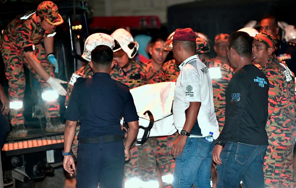 Anggota Jabatan Bomba dan Penyelamat Malaysia (JBPM) membawa keluar mayat salah seorang daripada dua mangsa nahas pesawat ringan model BK160 Gabriel yang terhempas di Kampung Tok Muda di sini petang Feb 13 untuk dibawa ke Hospital Tengku Ampuan Rahimah (HTAR) Klang bagi proses bedah siasat. - fotoBERNAMA