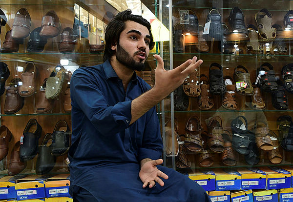 Afghan refugee Shahzad Alam speaks during an interview with AFP at his shoe shop in the historic Qissa Khawani bazaar in Peshawar. — AFP