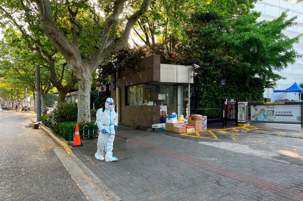 A worker in protective suit disinfects the ground in front of a residential compound amid the coronavirus disease (Covid-19) outbreak in Shanghai, China April 21, 2022. REUTERSpix