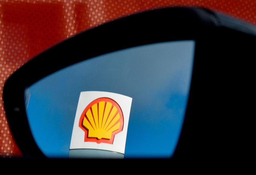 A Shell logo is seen reflected in a car’s side mirror at a petrol station in London. Shell will increase its distribution to shareholders to 20% to 30% of cash flow from operations beginning in the second quarter. – REUTERSPIX