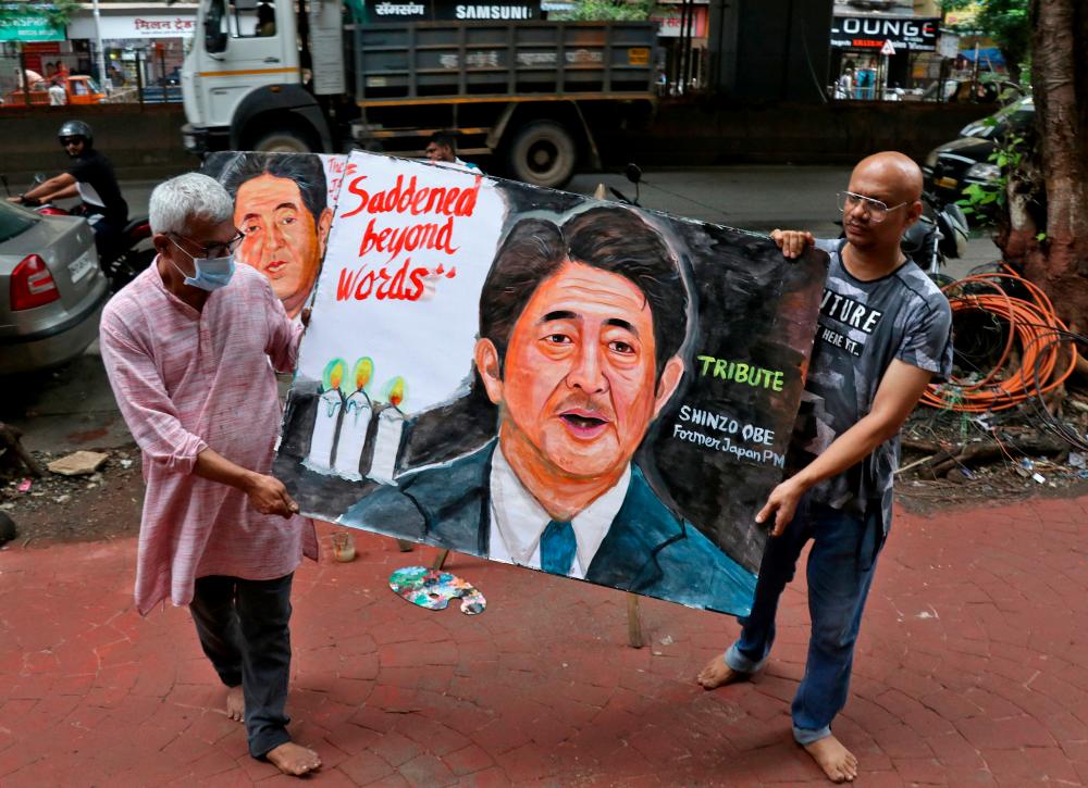 Artists carry a painting of late Japan's former Prime Minister Shinzo Abe, who died hours after he was shot while campaigning for a parliamentary election in Japanese western city of Nara, after they painted it as part of a tribute to him outside an art school in Mumbai, India, July 8, 2022. REUTERSpix