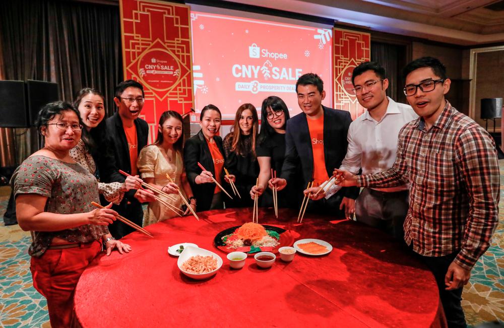 Tossing the yee sang at the Shopee Chinese New Year celebration. – Ashraf Shamsul/theSun