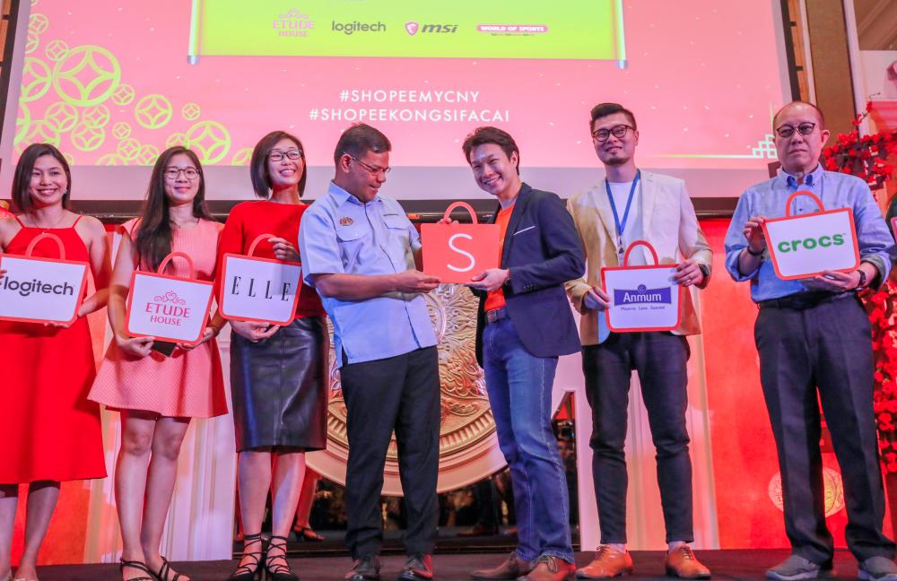 Saifuddin holding the Shopee app logo with Li. With them are representatives from the brands who launched their stores on Shopee. SUNPIX by AMIRUL SYAFIQ MOHD DIN