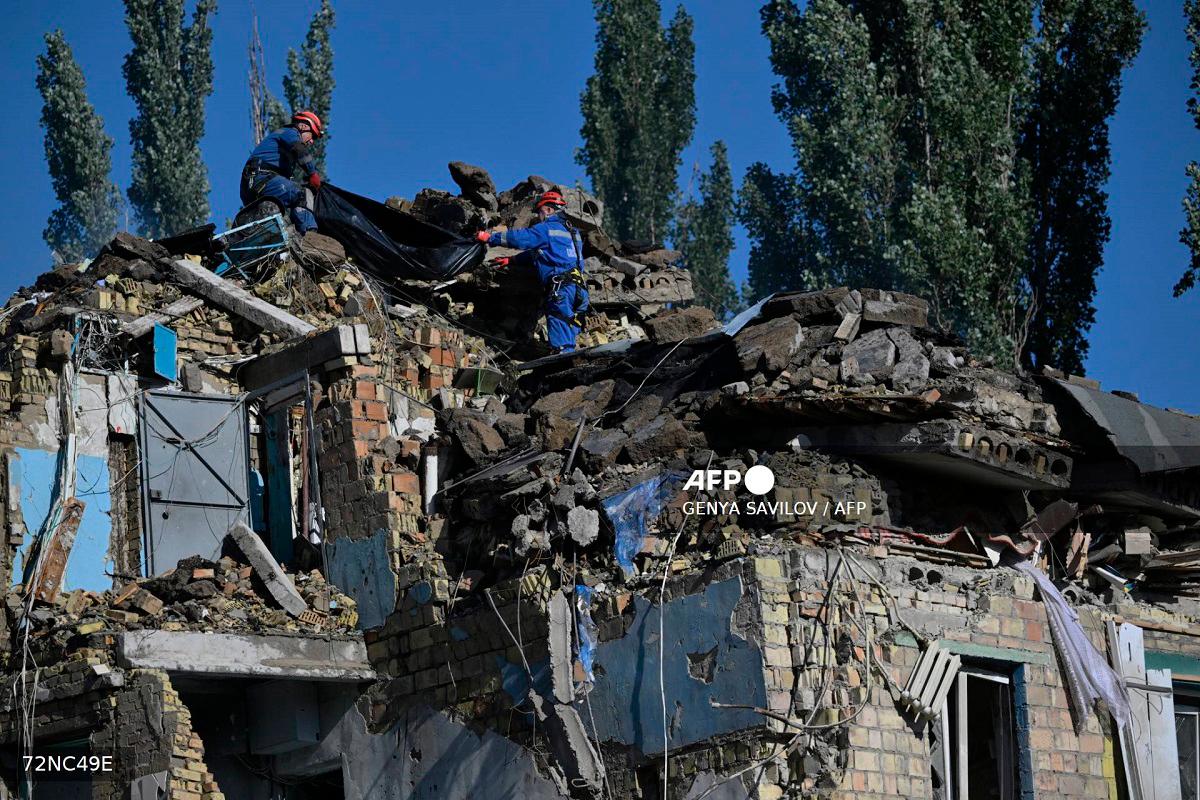 Ukrainian rescuers carry the body of a victim recovered during a search and rescue operation at the site of a residential building, heavily damaged following a Russian missile strike in Kyiv on August 28, 2025, amid the Russian invasion of Ukraine. - Genya SAVILOV / AFP