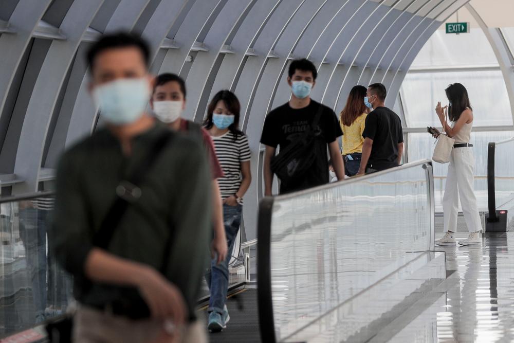 Visitors on a travelator head towards the Jewel Changi Airport mall in Singapore, 30 July 2020. - EPA