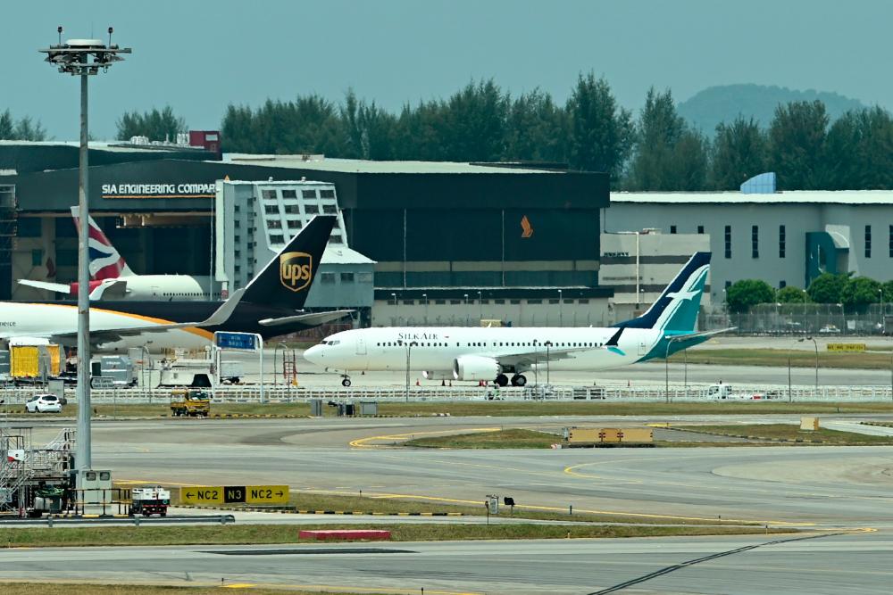 A SilkAir Boeing 737 MAX aircraft (C) is parked on the tarmac of Changi International Airport in Singapore on March 12, 2019. — AFP