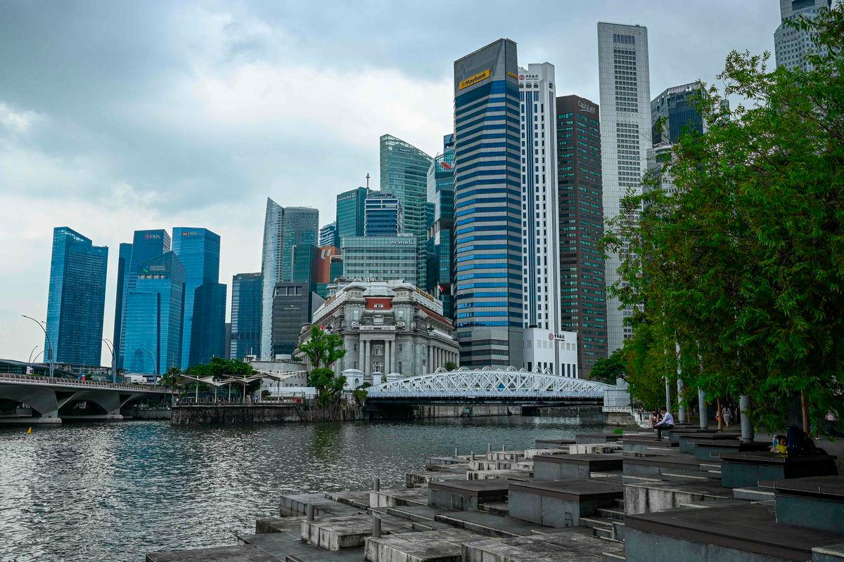 People sit along the promenade under a cloudy sky during lunchtime in the financial district of Raffles Place in Singapore on May 22, 2025. AFPpix