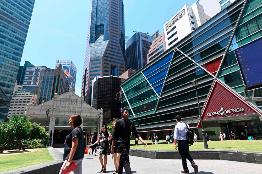 People walk past buildings in the financial business district of Raffles Place in Singapore on Oct 14, 2019. AFPPIX