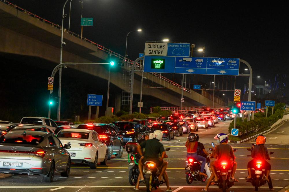 Vehicles form a long queue to enter the Woodlands Checkpoint in Singapore early on April 1, 2022, before crossing the causeway to Malaysia's southern Johor state, as both countries reopen its borders to all fully vaccinated travellers. AFPPIX