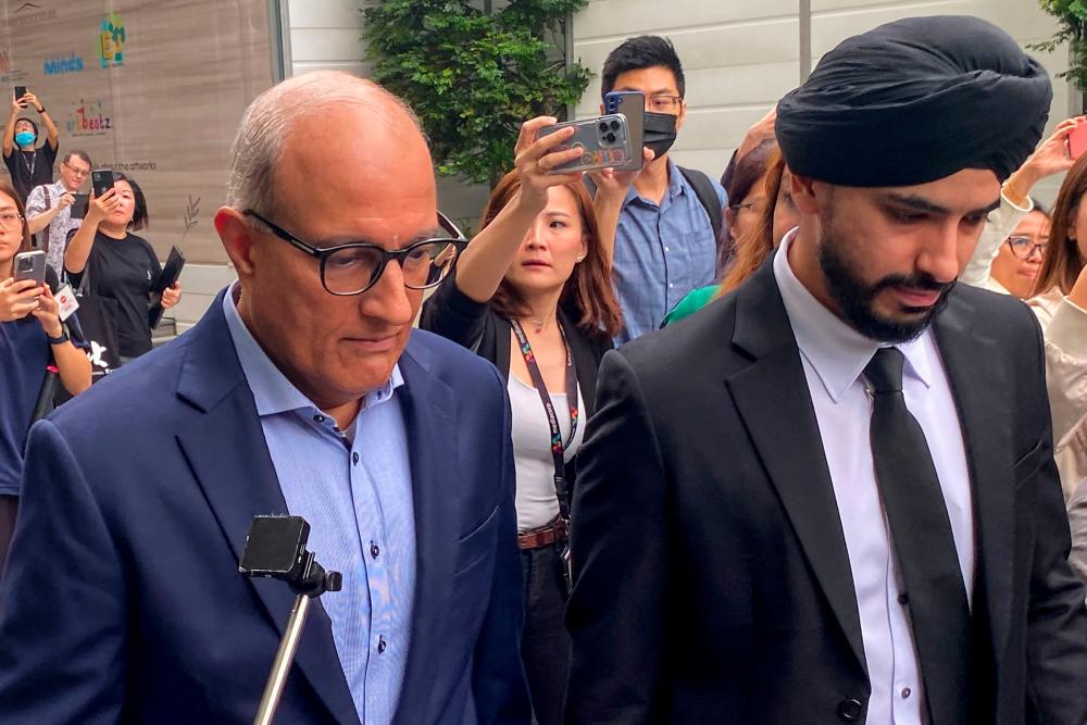 Singapore's Minister for Transport and Minister-in-charge for Trade Relations S. Iswaran (L) leaves the State Court in Singapore on January 18, 2024. - AFPPIX
