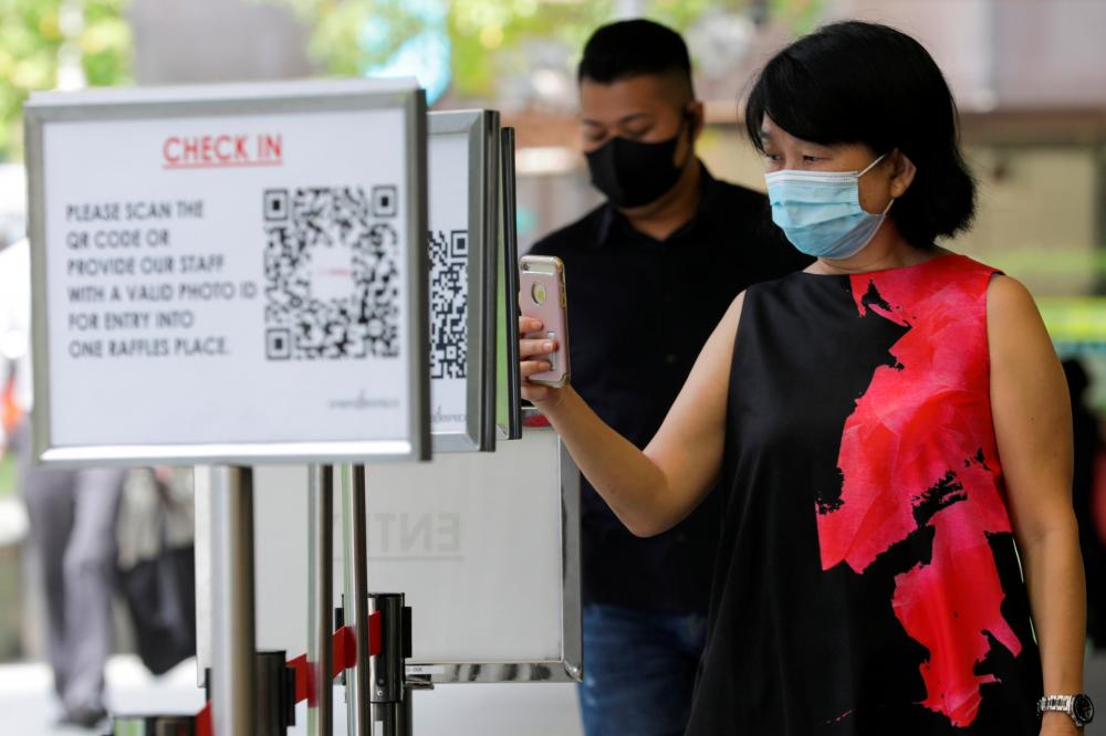 Office workers scan a Safe Entry QR code to enter a mall, amid the coronavirus disease (Covid-19) outbreak in Singapore May 12, 2021. — Reuters