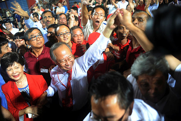 Photo shows Singaporean presidential candidate Tan Cheng Bock (2L) greeting his supporters as he waits for the results of the presidential elections at Jurong east Stadium in Singapore.