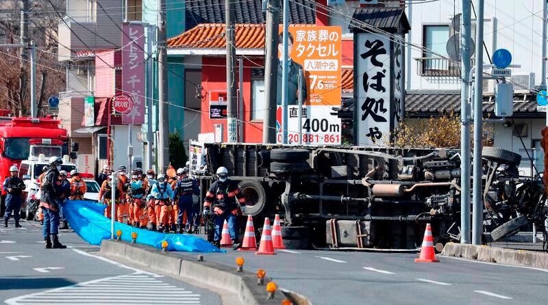 Rescue operations continue for a truck driver after his vehicle was swallowed up by a sinkhole at a prefectural road intersection the day before, in the city of Yashio, Saitama Prefecture on January 29, 2025. - JIJI PRESS / AFP