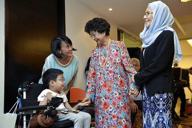 Tun Dr Siti Hasmah Mohd Ali shares a light moment with Branden Lim who suffers from ‘spinal muscular athrohy’ after presenting donations to the Malaysian Rare Disorders Society, National Autism Society of Malaysia and Childline Malaysia, on Dec 4, 2018. — Bernama