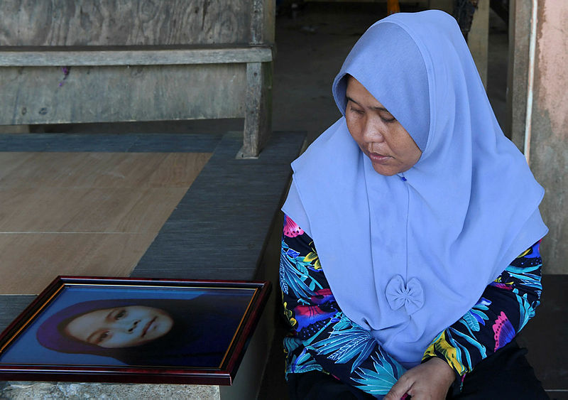 Filepix of Siti Masitah Ibrahim’s mother Solihah Abdullah looking at the photo of her daughter who was murdered, on Feb 11, 2019. — Bernama