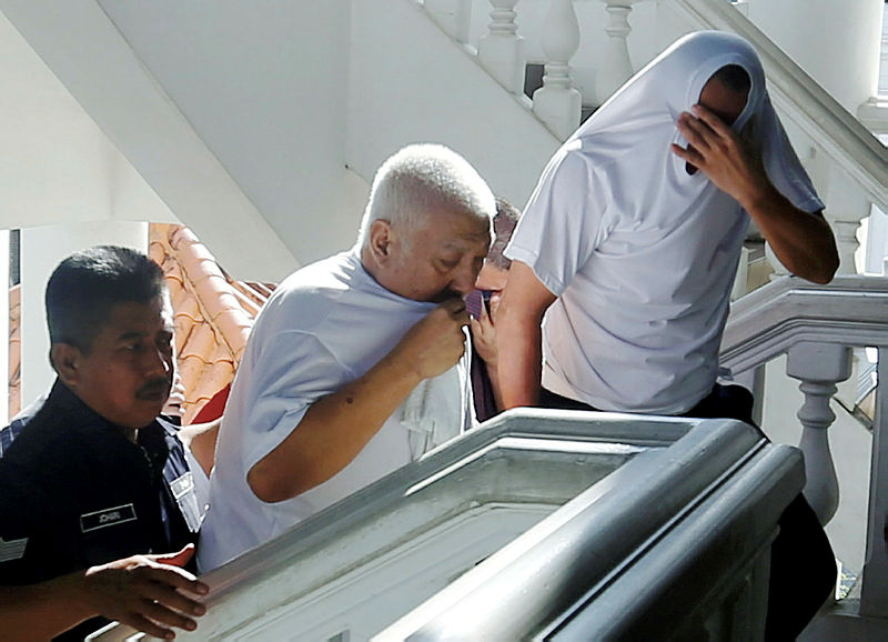 Six individuals, including the Penang National Registration Department (NRD) assistant director, who are facing 32 charges in connection with the issuance and sale of MyKad to foreigners, are led to the Penang High Court, on Oct 10, 2019. — BBX-Images