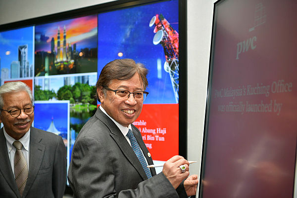 Chief Minister Datuk Patinggi signing an official plaque at the PwC.