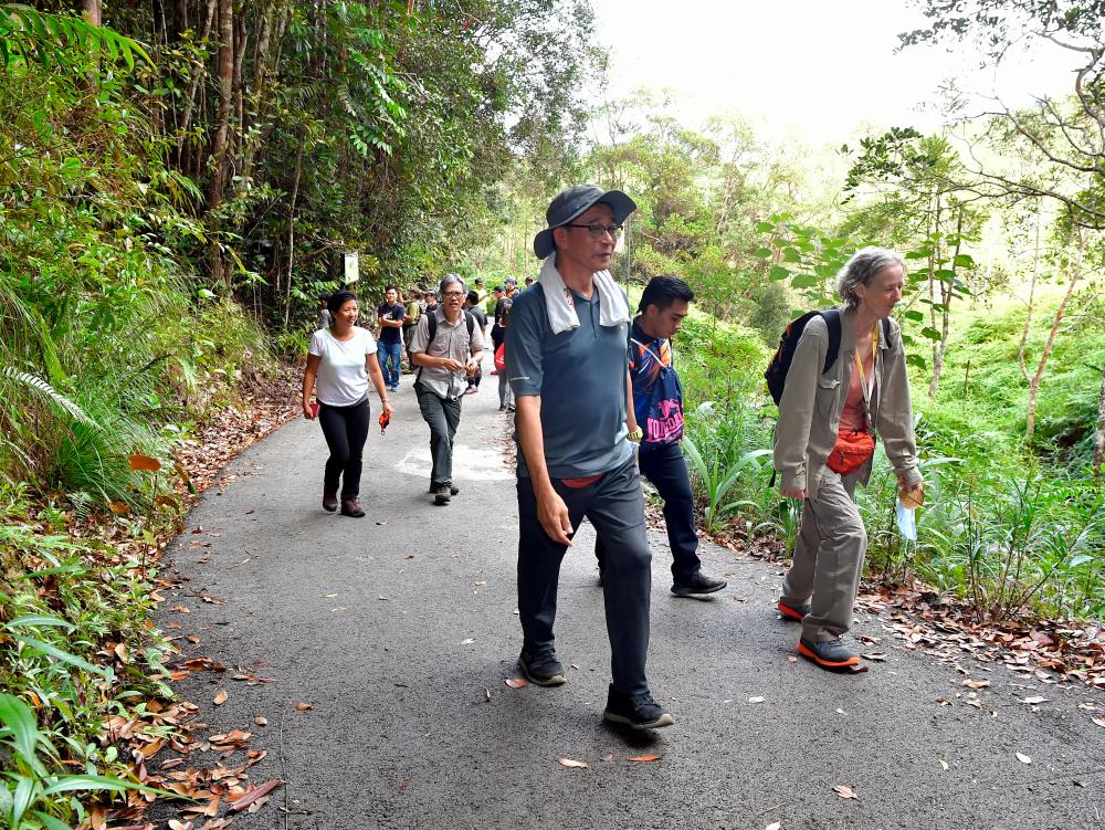 Sarawak Tourism, Arts and Culture Minister Datuk Abdul Karim Rahman Hamzah walks on foot to the launch of the Beccari Discovery Trail in Bukit Matang, near Kuching today. - Bernama