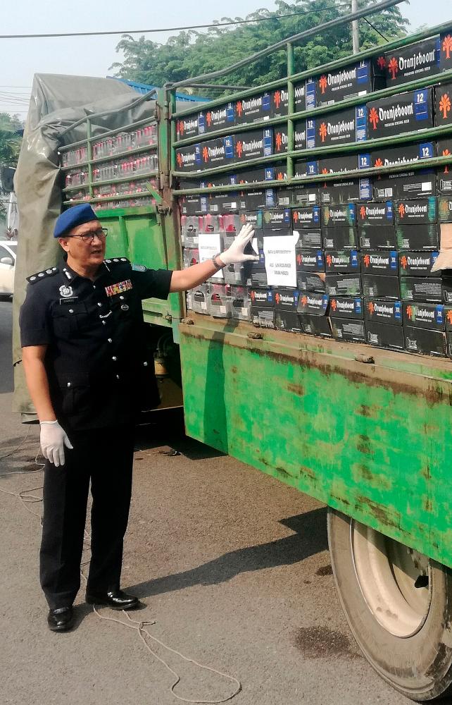 Sarawak Marine Police Region Five commander ACP Shamsol Kassim with the detained lorry. — Bernama