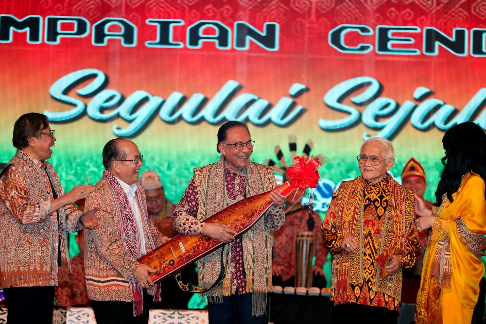 KUCHING, June 7 -- Prime Minister Datuk Seri Anwar Ibrahim (centre) tries the traditional Sarawak musical instrument ‘sape’ at the 2023 Gawai Dayak Festival at the Borneo Convention Center Kuching last night. BERNAMAPIX