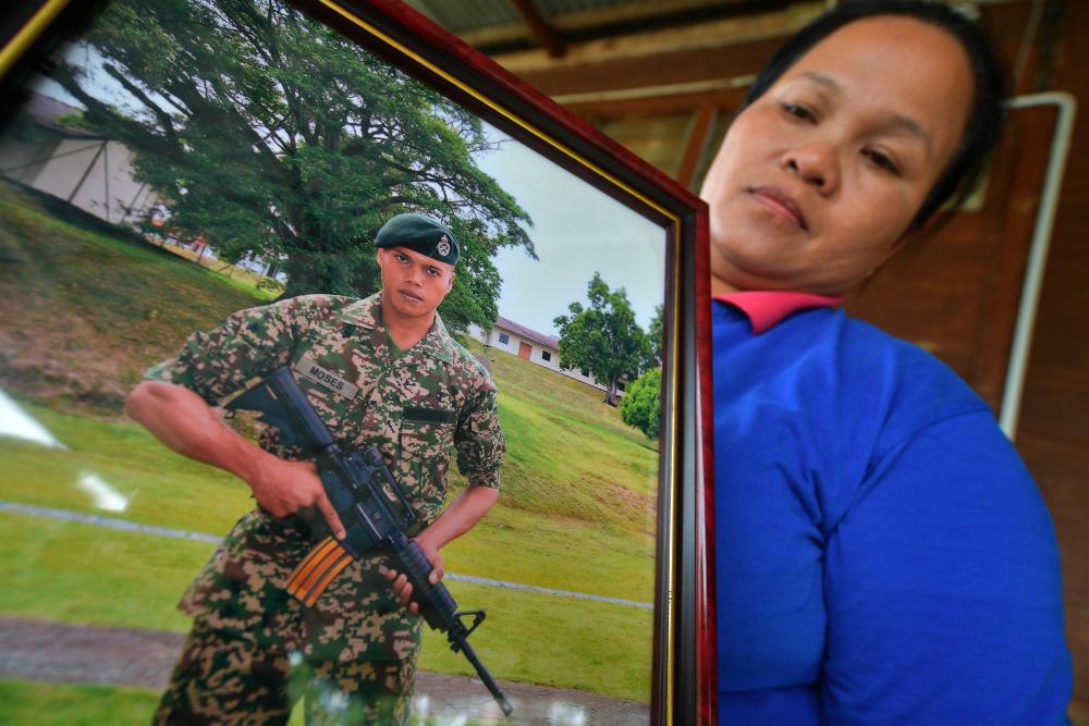 Kimkee Jiwa, 50, shows a picture of her nephew, L/Cpl Moses Logers, 25, who was reported missing while on duty on Pulau Perak in Kedah from last Friday when met by Bernama at her residence in Kampung Senibong, Bau near Kuching yesterday. - Bernama