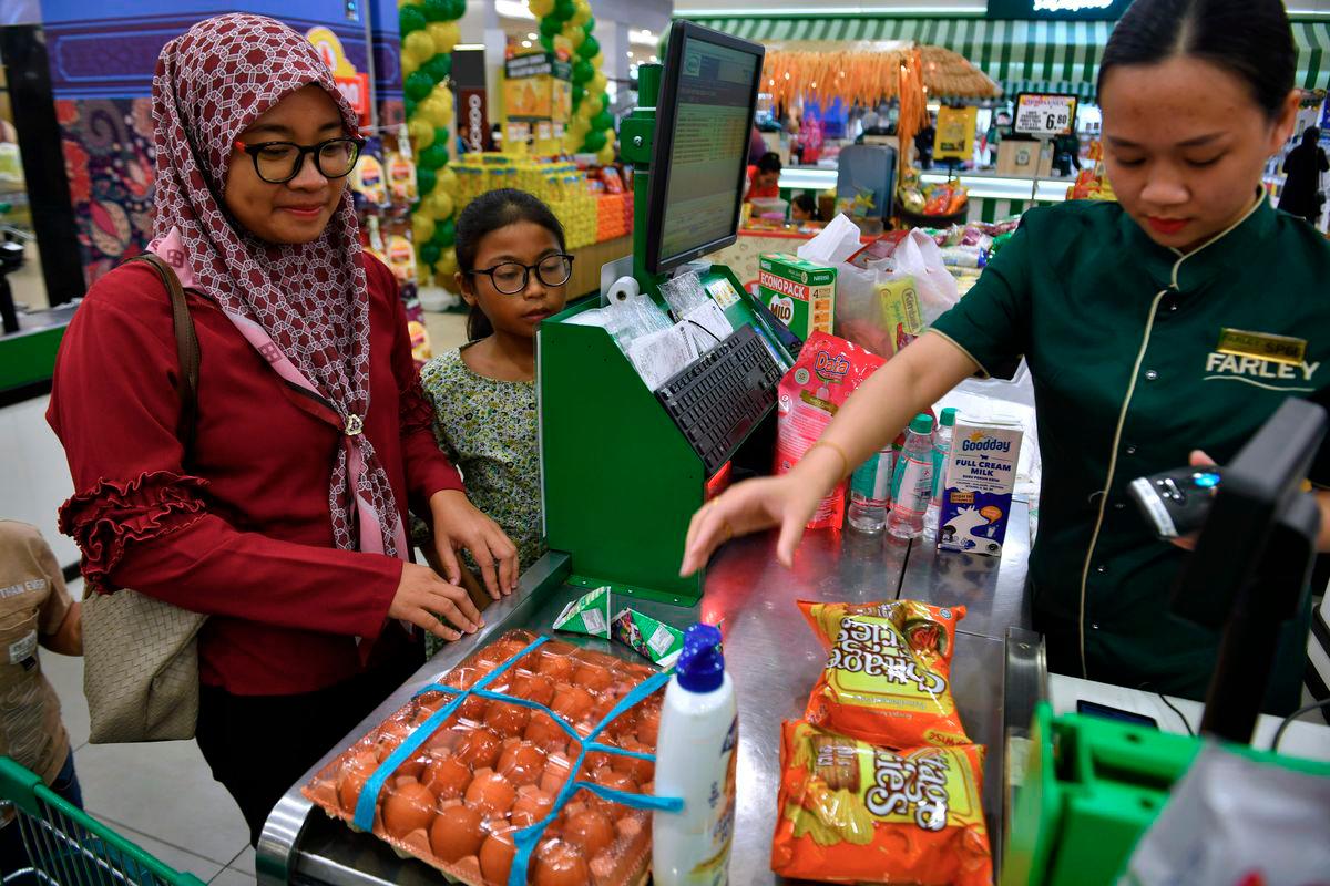 Sumbangan Asas Rahmah (SARA) recipients purchased essential items using the aid at Farley Supermarket yesterday. - BERNAMA