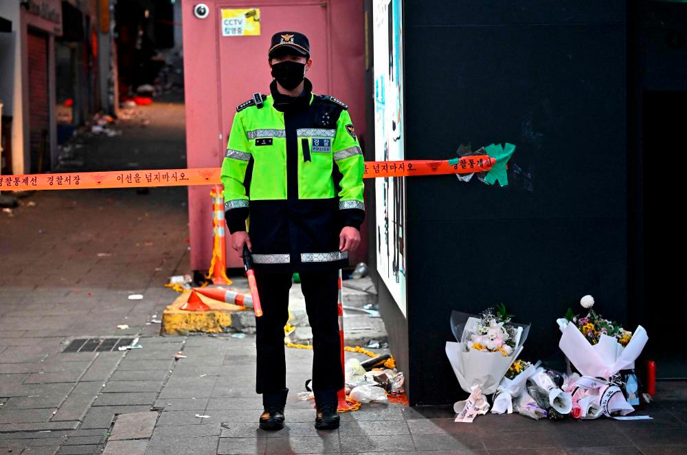 Police officer stands guard at the cordoned scene of the deadly Halloween crowd surge in the district of Itaewon in Seoul on November 1, 2022. AFPPIX
