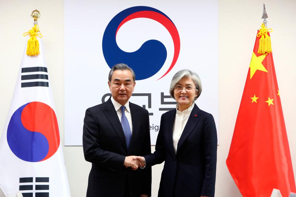 South Korea's Foreign Minister Kang Kyung-wha (R) shakes hands with China's Foreign Minister Wang Yi (L) during their meeting at the foreign ministry in Seoul on December 4, 2019. - AFP