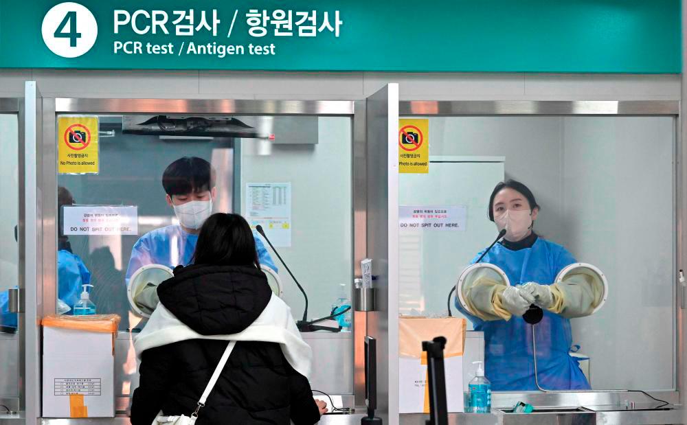 A health worker takes a nasal swab from a traveller arriving from China at a Covid-19 testing centre at Incheon International Airport, west of Seoul on January 3, 2023. AFPPIX