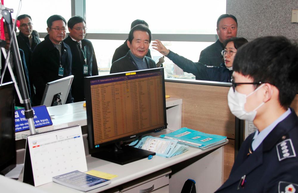 South Korea's Prime Minister Chung Sye-kyun (C) checks the quarantine efforts against the new coronavirus as he visits the customs, immigration and quarantine (CIQ) area at Incheon international airport, west of Seoul, on Jan 24. — AFP