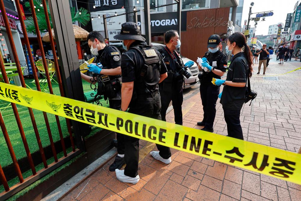 Police officers investigate the scene of an attack near the Sillim subway station in southwest Seoul on July 21, 2023/AFPPix