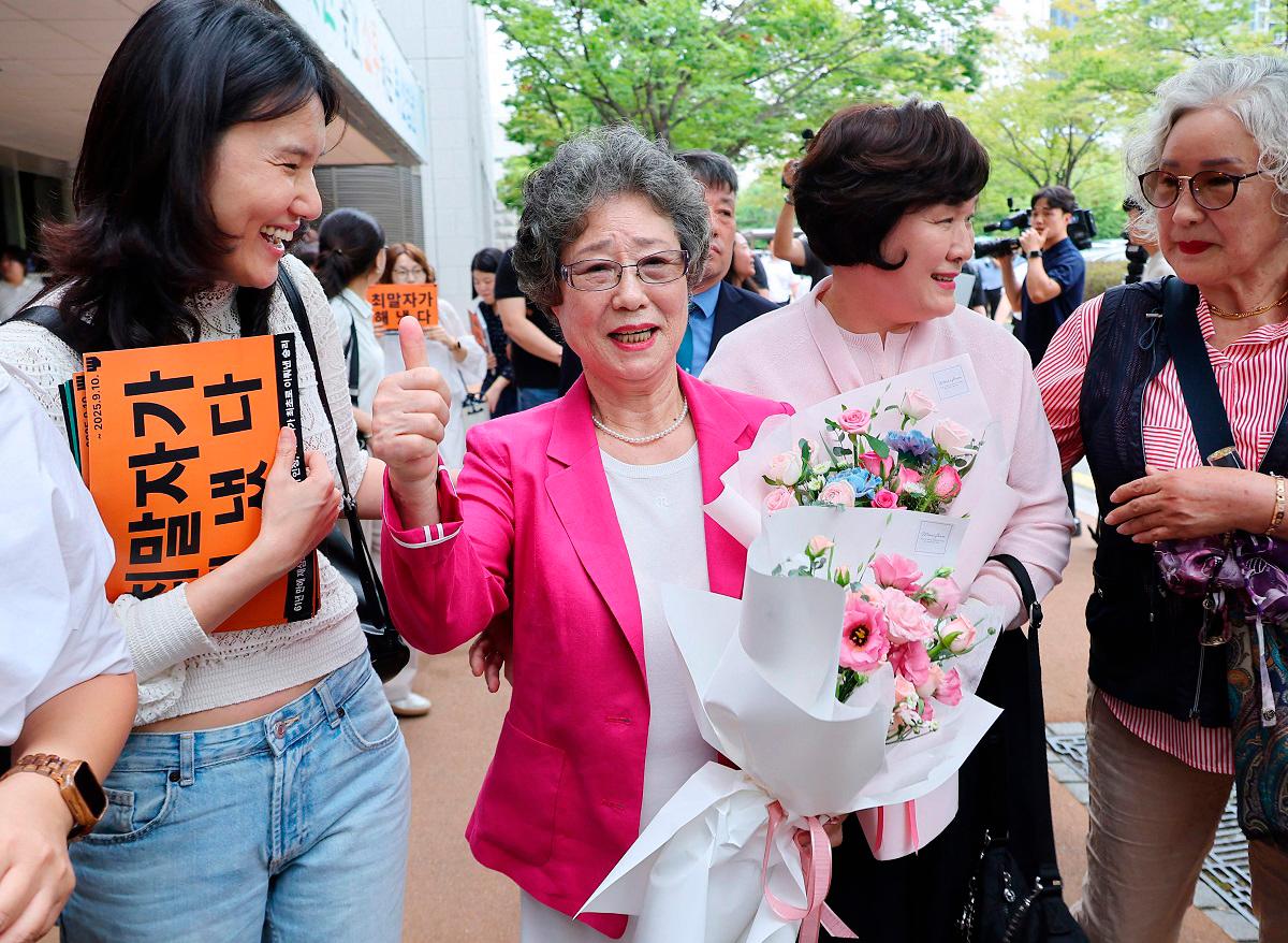 Choi Mal-ja (C), who was convicted 61 years ago for biting off the tongue of her attempted rapist, reacts after her retrial at the Busan District Court in Busan on September 10, 2025. - YONHAP / AFP