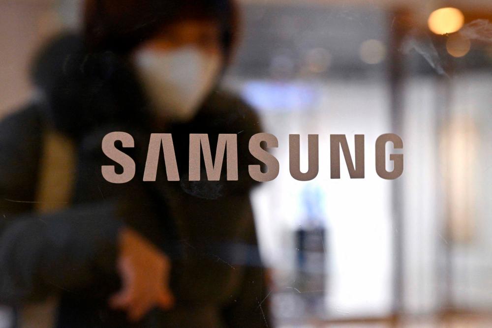 A woman walks past the Samsung logo displayed on a glass door at the company’s Seocho building in Seoul on January 31, 2023/AFPPix