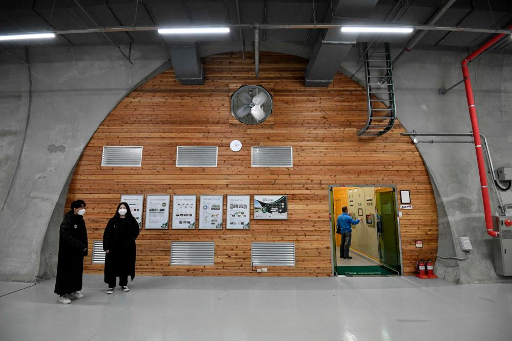This picture taken on May 21, 2021 shows officials preparing to enter a storage room in a tunnel at the Baekdudaegan National Arboretum Seed Vault Centre in the southeastern mountainous county of Bonghwa. Buried in a South Korean mountain, in a tunnel designed to withstand a nuclear blast, the seeds of nearly 5,000 wild plant species are stored for safekeeping against climate change, natural disaster and war. – AFP
