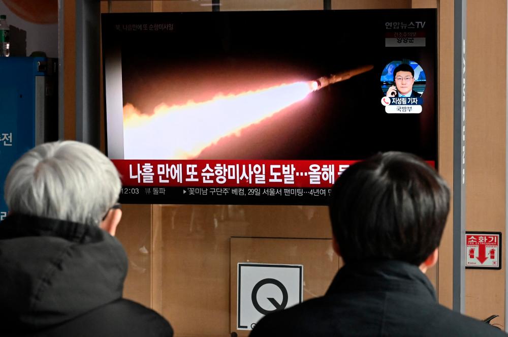 People watch a television screen showing a news broadcast with file footage of a North Korean missile test, at a railway station in Seoul on January 28, 2024. North Korea fired several cruise missiles on January 28, Seoul’s military said, the latest in a series of tension-raising moves by the nuclear-armed state/AFPPix