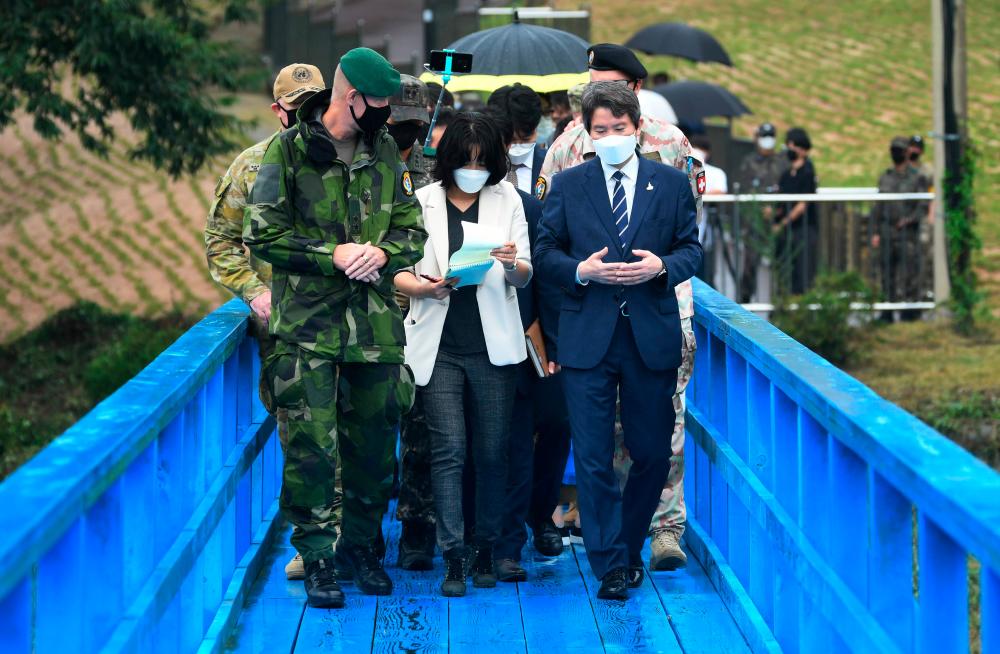 South Korean Unification Minister Lee In-young (R) walks with military officers on a blue bridge during a visit to the south side of the truce village of Panmunjom in the Demilitarized Zone (DMZ) dividing the two Koreas on September 16, 2020. — AFP