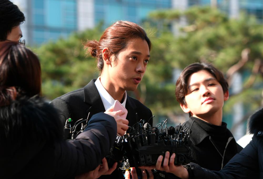 K-pop star Jung Joon-young (C) speaks to the media as he arrives for questioning at the Seoul Metropolitan Police Agency in Seoul on March 14, 2019. — AFP