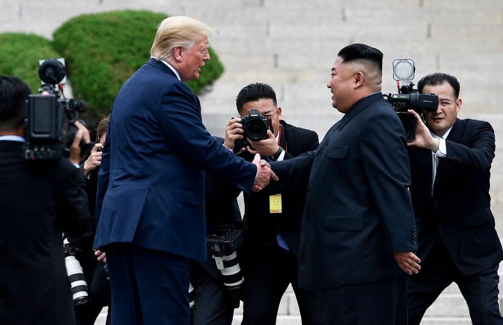 File photo taken on June 30 shows North Korea's leader Kim Jong Un shakes hands with US President Donald Trump north of the Military Demarcation Line that divides North and South Korea, in the Joint Security Area (JSA) of Panmunjom in the Demilitarized zone (DMZ). — AFP